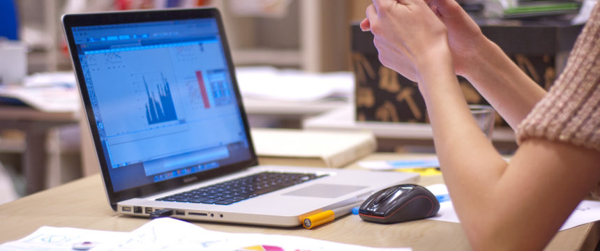 A person sitting at a desk, working on a laptop.
