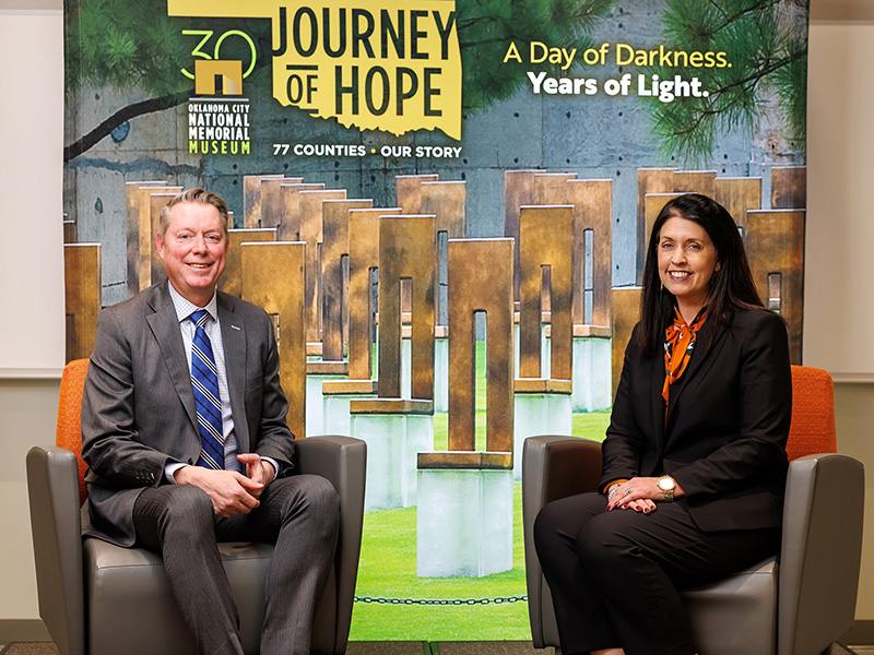 Jayson Lusk and Blayne Arthur in front of a backdrop with agriculture photos