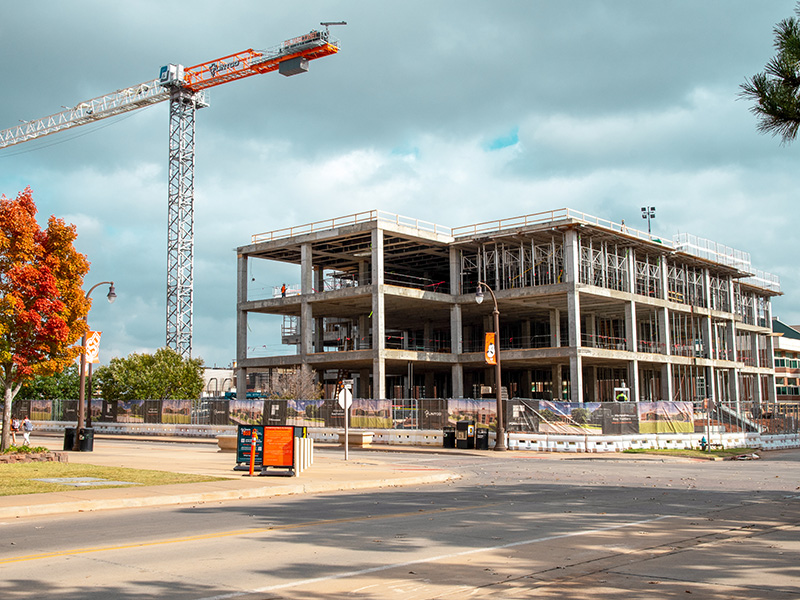 Construction Site for the New Frontiers Agricultural Hall. A crane with next to the skelaton of a three story building.