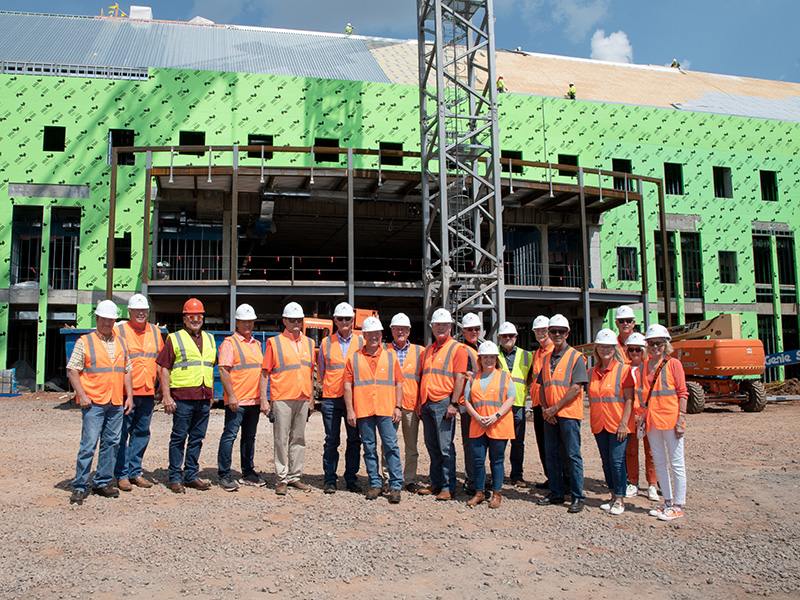 Finanical institution members in front of New Frontiers construction site