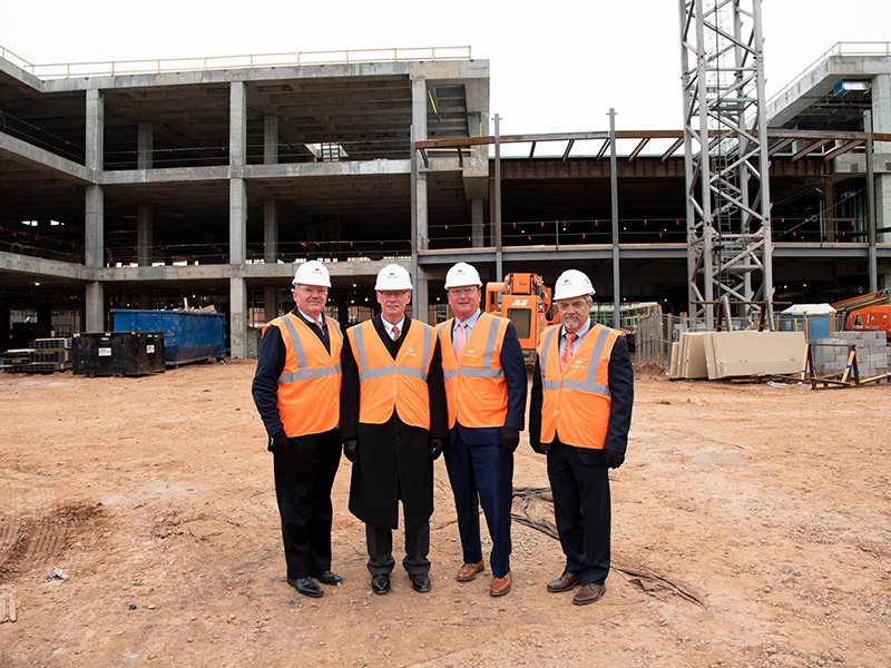 Regents stand in front of the new building