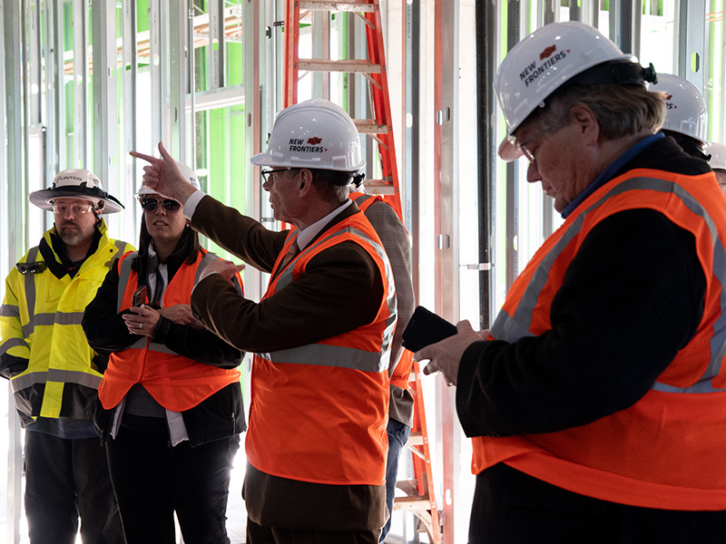 Tom Coon showing Dean's Advisory Council building progress