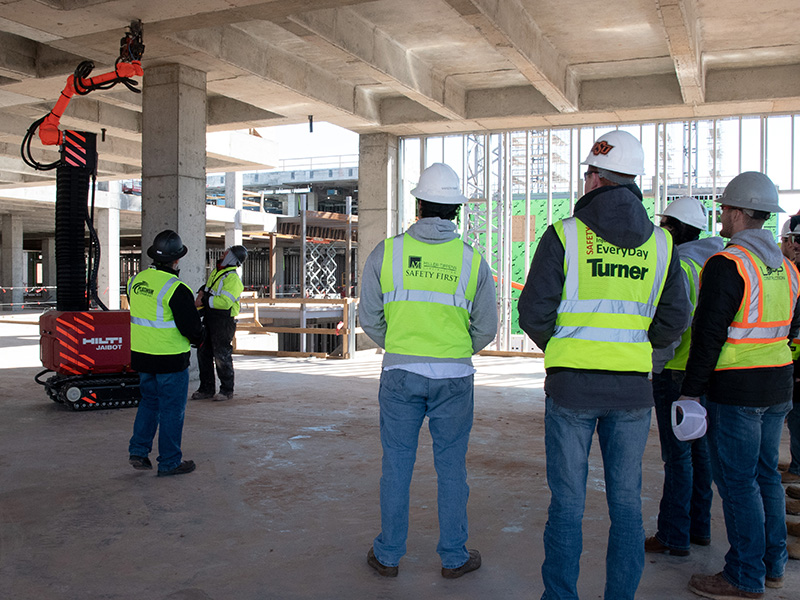 OSU students watch the jaibot robot in action on the construction site