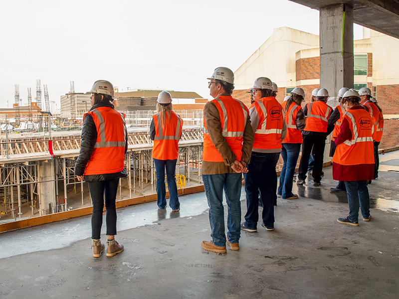 A group of men and women looking at a construction site. 
