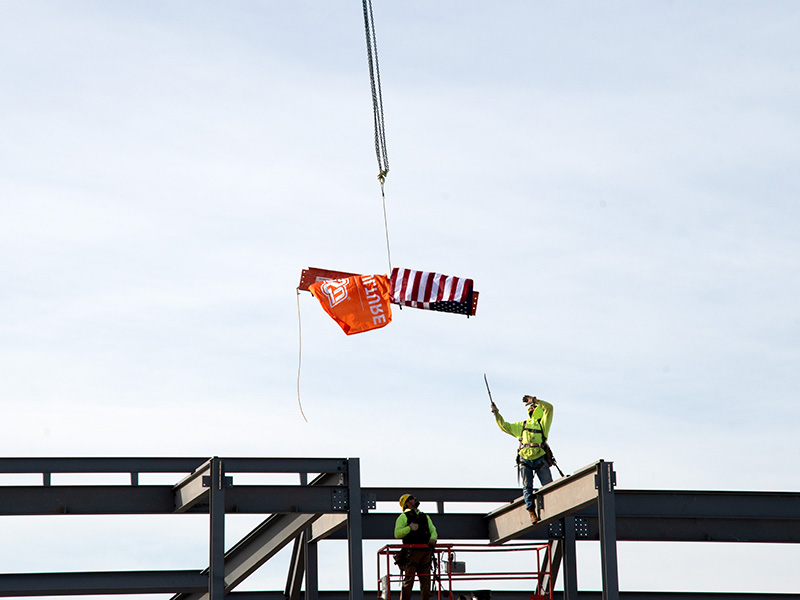 Construction workers ready to install signed beam