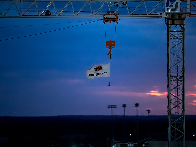 Night time shot of flag flying on New Frontiers construction crane